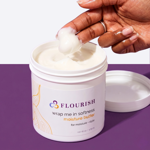 Hand scooping cream from a hair care jar on a purple background